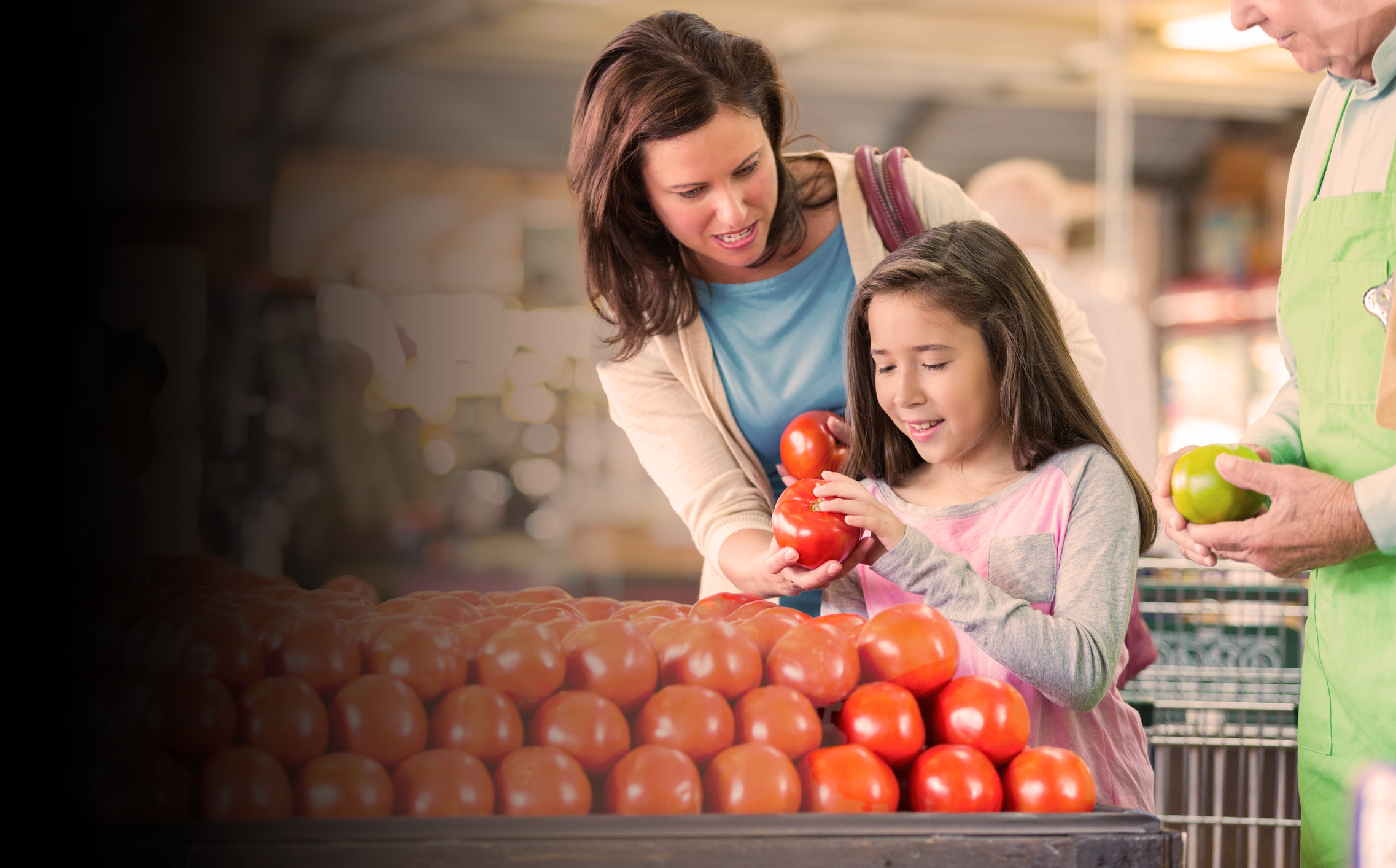 Mother and daughter shopping for tomatoes