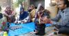 Man showing group of women a cookstove