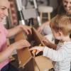 family with young boy unpacking moving boxes