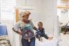 smiling Caribbean mother and child in a medical clinic