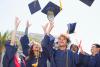 graduates throwing caps into air